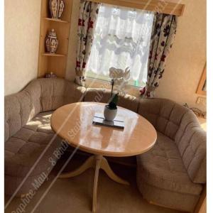 a living room with a table and a couch at 8 berth static caravan coral beach ingoldmells in Ingoldmells