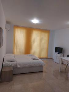 a bedroom with a bed and a table and a television at SAPPHIRE in Sozopol