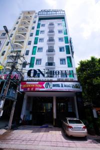een gebouw waar een auto voor geparkeerd staat bij ONE HOTEL in Vĩnh Long