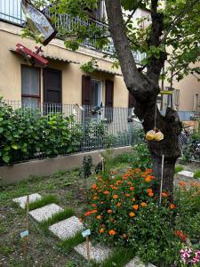 un giardino con un albero e fiori di fronte a un edificio di Darsena b&b tra arte e mare a Ravenna