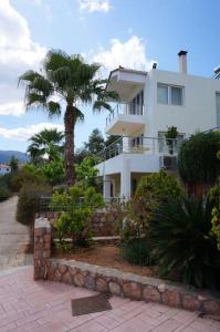 una casa blanca con una palmera delante de ella en The Sea Star - Korfos Sea View Villa, en Korfos