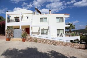 Casa blanca con pared de piedra en The Sea Star - Korfos Sea View Villa, en Korfos