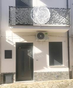 een wit gebouw met een balkon en een deur bij Nel borgo di Capri Leone in Capri Leone