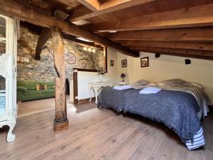 una camera con un letto in una stanza con un muro in pietra di Mirador de Lanchares a Lanchares