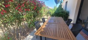 a wooden table and chairs on a balcony with flowers at Casarella Alzia in Santa-Reparata-di-Balagna