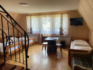 a small room with two beds and a table and chairs at Felągówka in Murzasichle