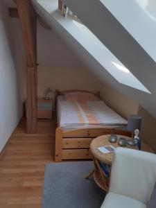 ein Schlafzimmer mit einem Bett und einem Tisch im Dachgeschoss in der Unterkunft Ferienwohnung Tölle in Bad Rehburg
