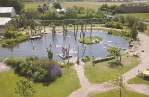 an aerial view of a park with a pond at Het Yorritje - tiny house nabij kust in Dirkshorn