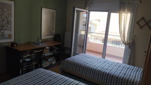 een slaapkamer met 2 bedden en een raam met een balkon bij Sevasti Country House in Sevastí