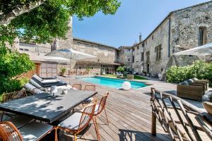 an outdoor patio with a table and chairs and a pool at La Chapelle sur la Sorgue in LʼIsle-sur-la-Sorgue