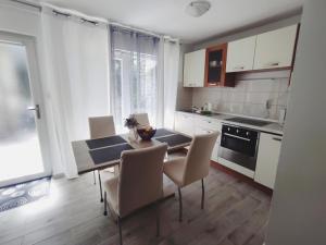 a kitchen with a dining room table and chairs at Apartments Emi & Nini in Šibenik