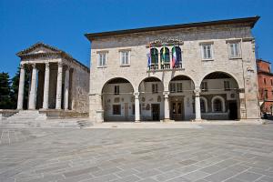 a large stone building with two flags on it at Apartment Mare in Pula