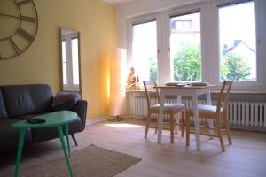 sala de estar con sofá, mesa y sillas en Akram Appartement II - Studio - Zentral und Ruhig, en Hildesheim