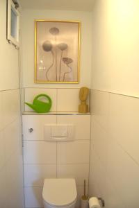 baño con aseo y una foto en la pared en Akram Appartement II - Studio - Zentral und Ruhig, en Hildesheim