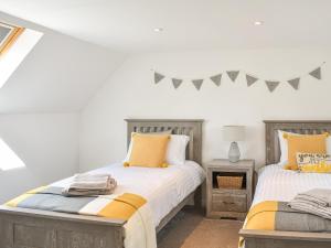 um quarto com 2 camas e uma mesa em Jock Mcmuffin Cottage em Portknockie