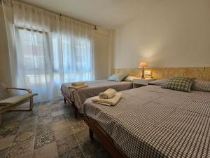 a bedroom with two beds and a window at 1A100 Moderno y acogedor in Gijón