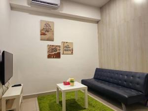 ein Wohnzimmer mit einem schwarzen Sofa und einem Tisch in der Unterkunft 1 Dream Home @ Utropolis Studio 4星级简单舒适享受漂亮夜景和泳池 in Shah Alam
