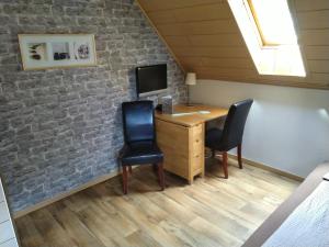 Zimmer im Dachgeschoss mit einem Schreibtisch und 2 Stühlen in der Unterkunft Farm Stay Heidehof in Hellenthal