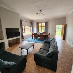 a living room with a couch and a table at Karoo Leeu Self Catering in Oudtshoorn