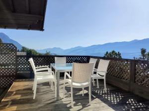 a table and chairs on a deck with mountains in the background at Alpendohle Apartments Innsbruck in Innsbruck