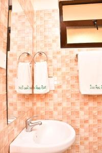 a bathroom with a sink and towels on the wall at Divine Homes Resort Kisumu in Kisumu