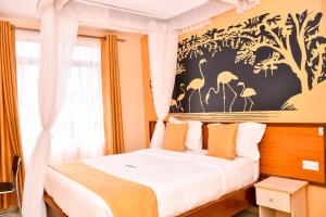 een slaapkamer met een bed met oranje kussens bij Divine Homes Resort Kisumu in Kisumu