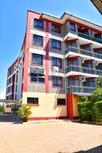 a tall red and white building on a street at Divine Homes Resort Kisumu in Kisumu