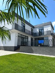 a large white house with a palm tree in front of it at White Villa Ismayilli in İsmayıllı