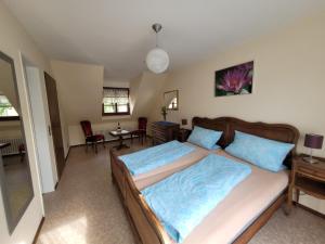 ein Schlafzimmer mit einem großen Bett mit blauen Kissen in der Unterkunft Ferienwohnung Alte Schmiede in Vogtsburg