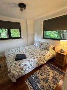 a bedroom with a bed and two windows at Borthwick Farm Cottage Pottery in Borthwick