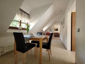 a dining room with a wooden table and black chairs at Ferienwohnung Alte Schmiede in Burkheim