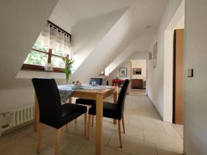 a dining room with a wooden table and black chairs at Ferienwohnung Alte Schmiede in Vogtsburg