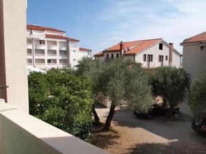 a view of a courtyard with trees and a building at Apartments Mira in Tučepi