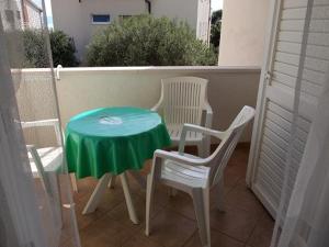 a green table and two chairs on a balcony at Apartments Mira in Tučepi