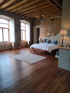 een slaapkamer met een bed en een bakstenen muur bij Quinta do Passal in Arega
