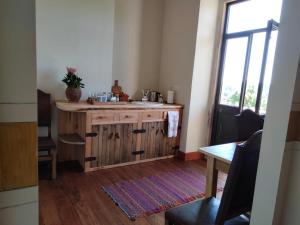 a kitchen with a sink and a table and a window at Quinta do Passal in Arega