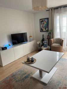 uma sala de estar com uma mesa e uma televisão em Jessi home em Limeil-Brévannes
