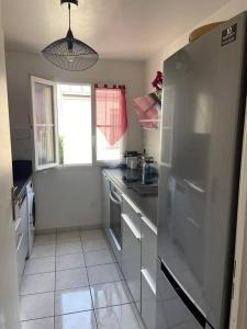 uma cozinha com um frigorífico e uma janela em Jessi home em Limeil-Brévannes