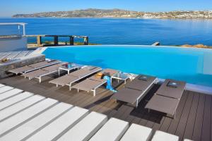 una terraza con sillas y una piscina en un crucero en Villa Indigo - Mykonos, en Mykonos ciudad 6 fotos más