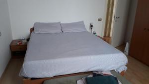 a bed in a small room with a white bedsheet at Lorenzo's House in Thiene