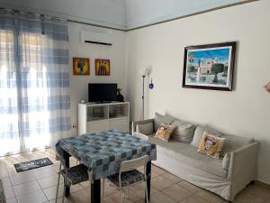 un soggiorno con un divano e un tavolo di Casa Vacanza Sicilia Dolce Mare a Balestrate