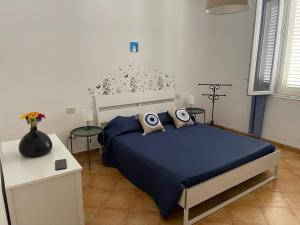 una camera con un letto blu e due tavoli di Casa Vacanza Sicilia Dolce Mare a Balestrate