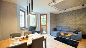 a living room with a blue couch and a table at Apartamenty EverySky - Nad Łomnicą 14A-B in Karpacz