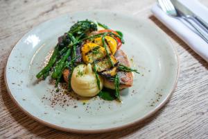 a plate of food with vegetables on a table at The Canford in Poole
