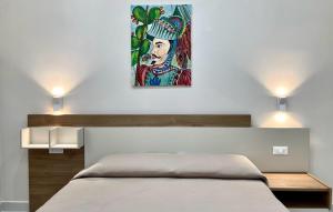 a bedroom with a bed with a painting on the wall at Perle di Sicilia in Milazzo