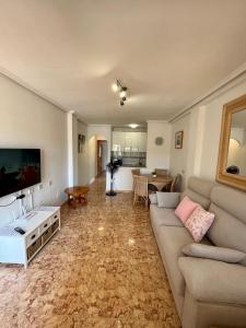 un soggiorno con divano e tavolo di Tranquil Self Catering Golf Course Apartment ad Alicante