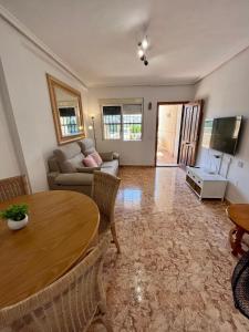 un soggiorno con tavolo e divano di Tranquil Self Catering Golf Course Apartment ad Alicante