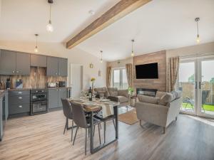 a kitchen and living room with a table and chairs at West End Farm Lodge Alabaster in Lydbrook