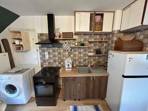 une petite cuisine avec un évier et une machine à laver dans l'établissement Mansarda veche - central, balcony, self check-in, à Sinaia 14 autres photos