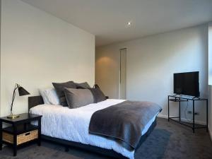a bedroom with a bed and a flat screen tv at Large Executive 3 bedroom in Yarralumla